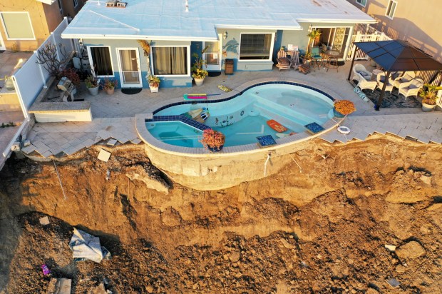 SAN CLEMENTE, CALIFORNIA - MARCH 16: An aerial view of a remaining pool at the edge of a hillside landslide brought on by heavy rains, which caused four ocean view apartment buildings to be evacuated and shuttered due to unstable conditions, on March 16, 2023 in San Clemente, California. Weeks of rains loosened the soil in Orange County which tumbled down near railroad tracks that run next to the beach below. (Photo by Mario Tama/Getty Images)